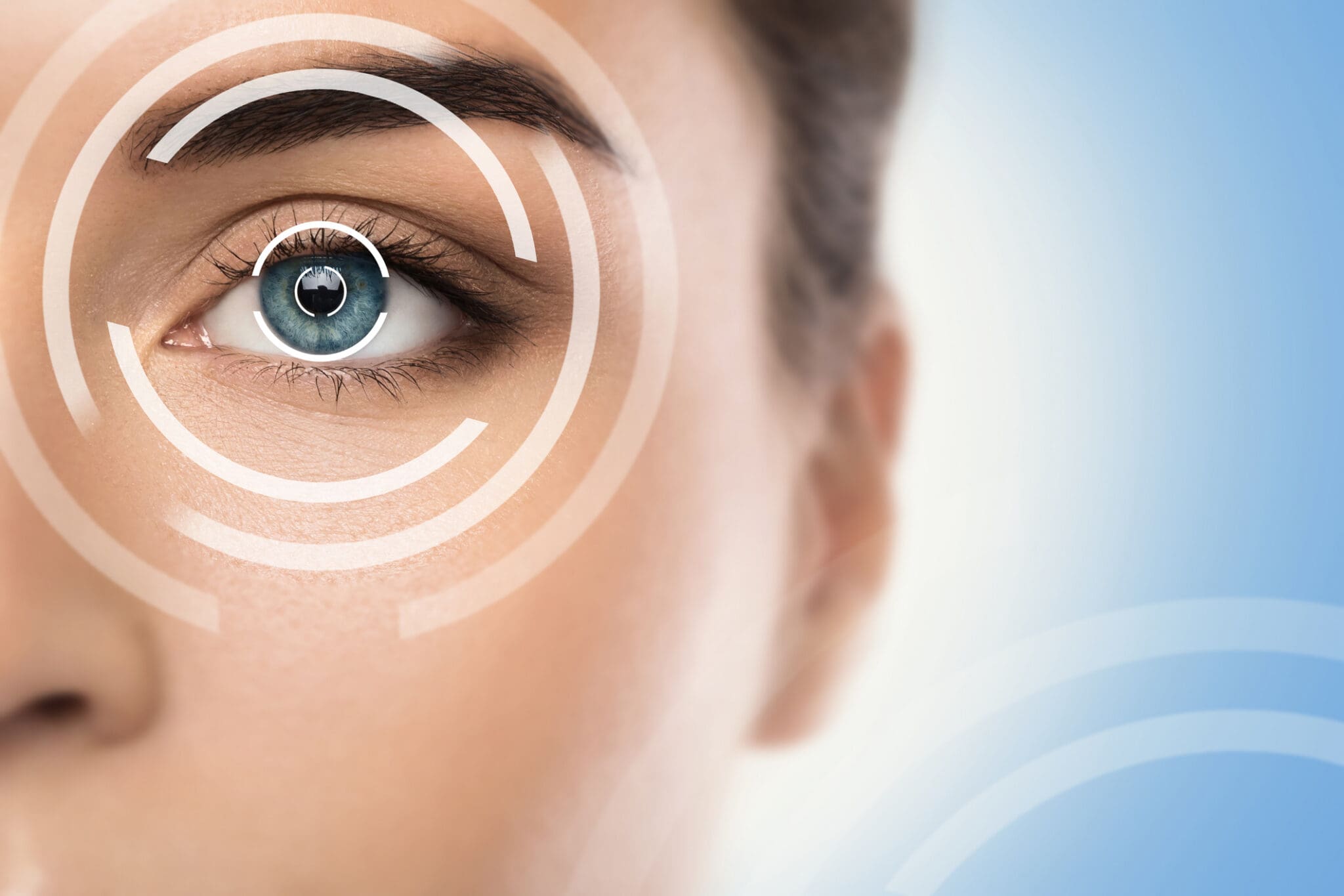 Concepts of laser eye surgery or visual acuity check-up A woman with blue eyes and white circles around her eye.